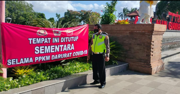 Petugas Pasang Spanduk Penutupan Sementara Tempat Usaha dan Fasilitas Wisata di Gianyar.
